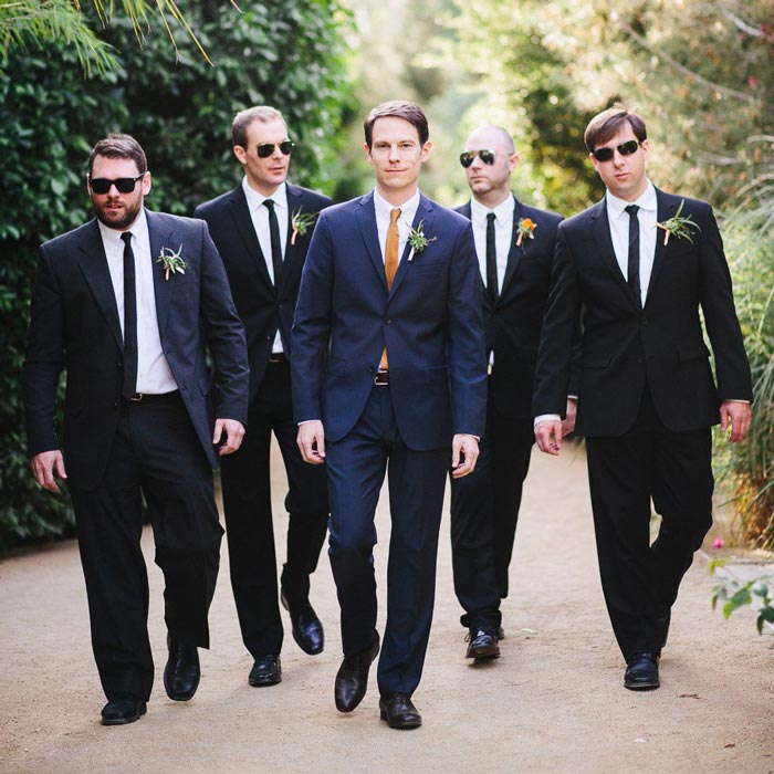 group of men walking together in suits confident