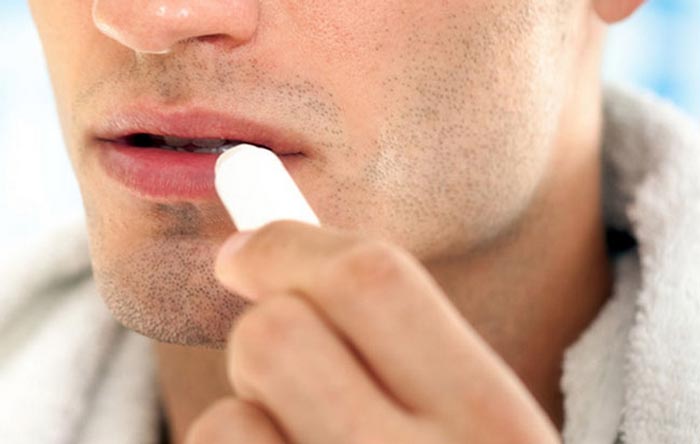 man applying lip balm